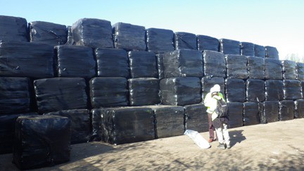 Investigators inspect waste disguised as hay-bales at a site near Waltham Forest